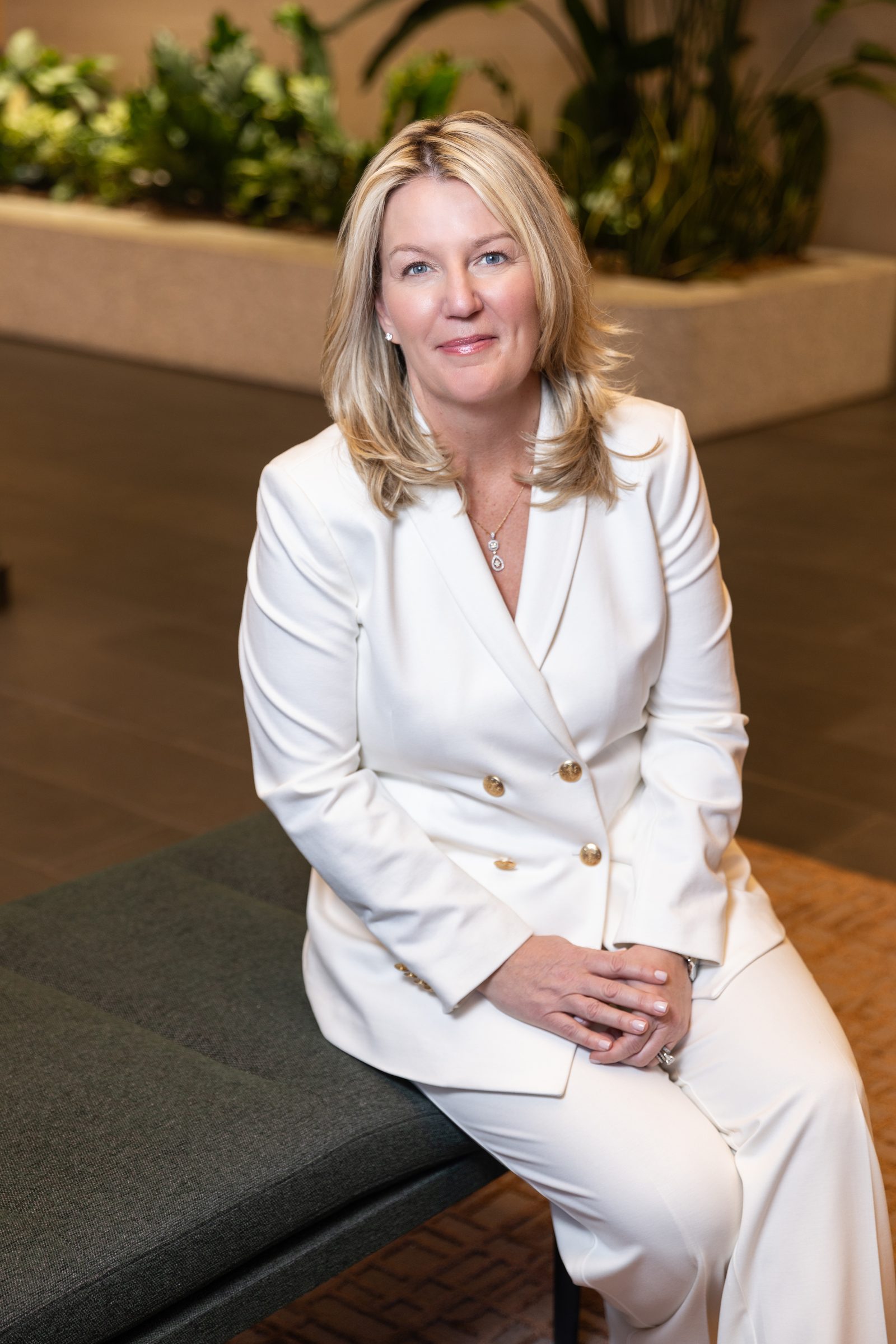 Erin Lanuti, AI strategy and innovation executive, seated in a white suit
